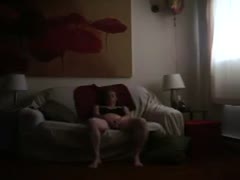 A gorgeous, naturally plump redhead rests on the ottoman and engages in masturbation.